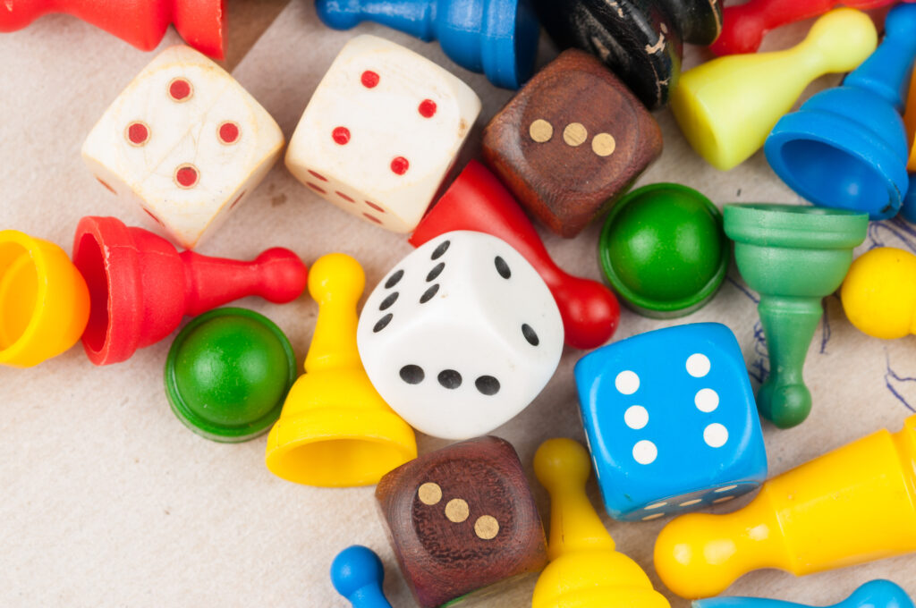 Colorful board game pieces and dice scattered on a tabletop