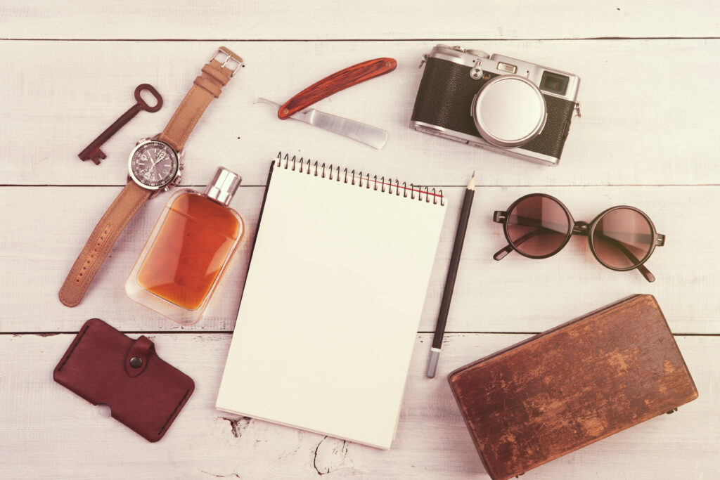 Everyday men’s accessories arranged on a light wooden surface.